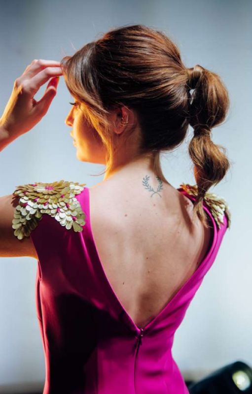 Modelo femenina de espaldas con un pequeño giro hacia la izquierda. Se muestra pelo recogido en coleta. Foto realizada durante reportaje fotográfico en Menorca.